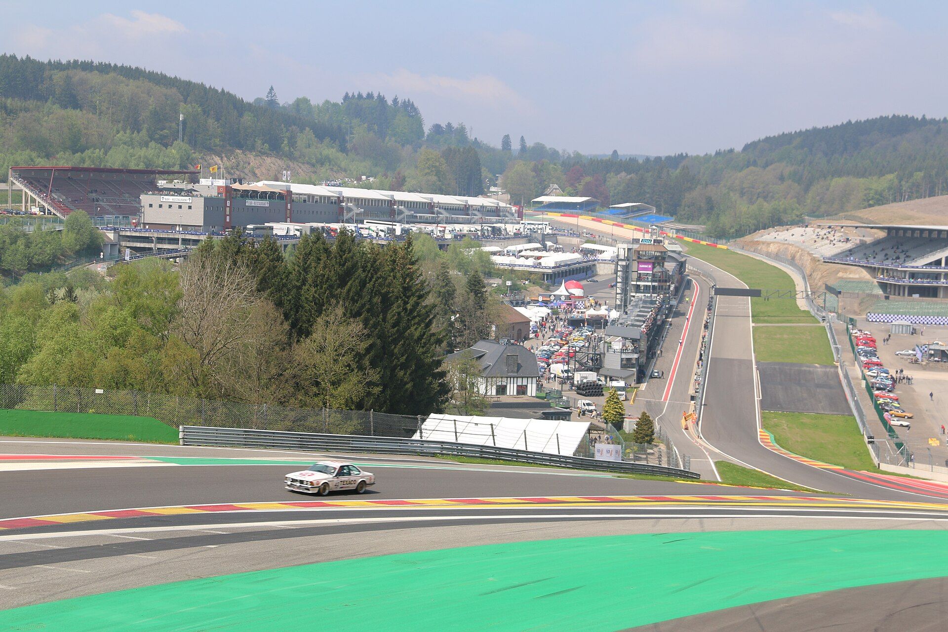 Prosta startowa, boksy i trybuny toru Spa-Francorchamps widziane znad nawrotu La Source